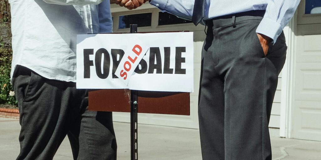 Apretón de manos frente a una vivienda — venta internacional